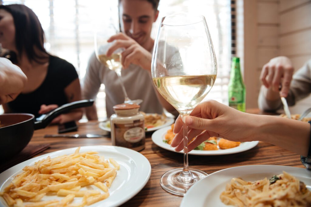 closeup of people drinking wine and eating pasta a PK94KTL scaled 1